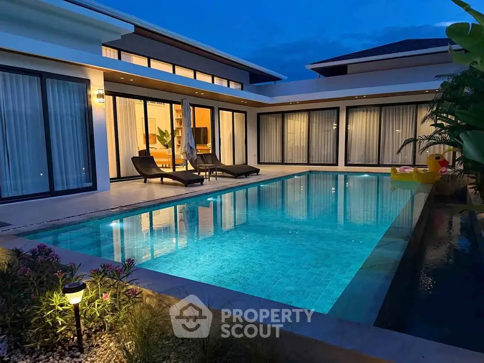 Luxurious modern villa with stunning pool and elegant outdoor lighting at dusk.