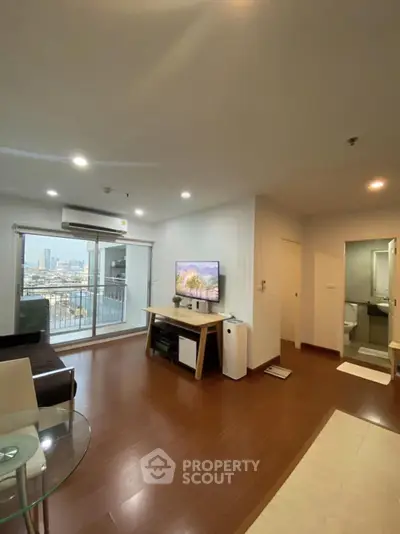 Modern living room with city view, featuring sleek furniture and large windows for natural light.