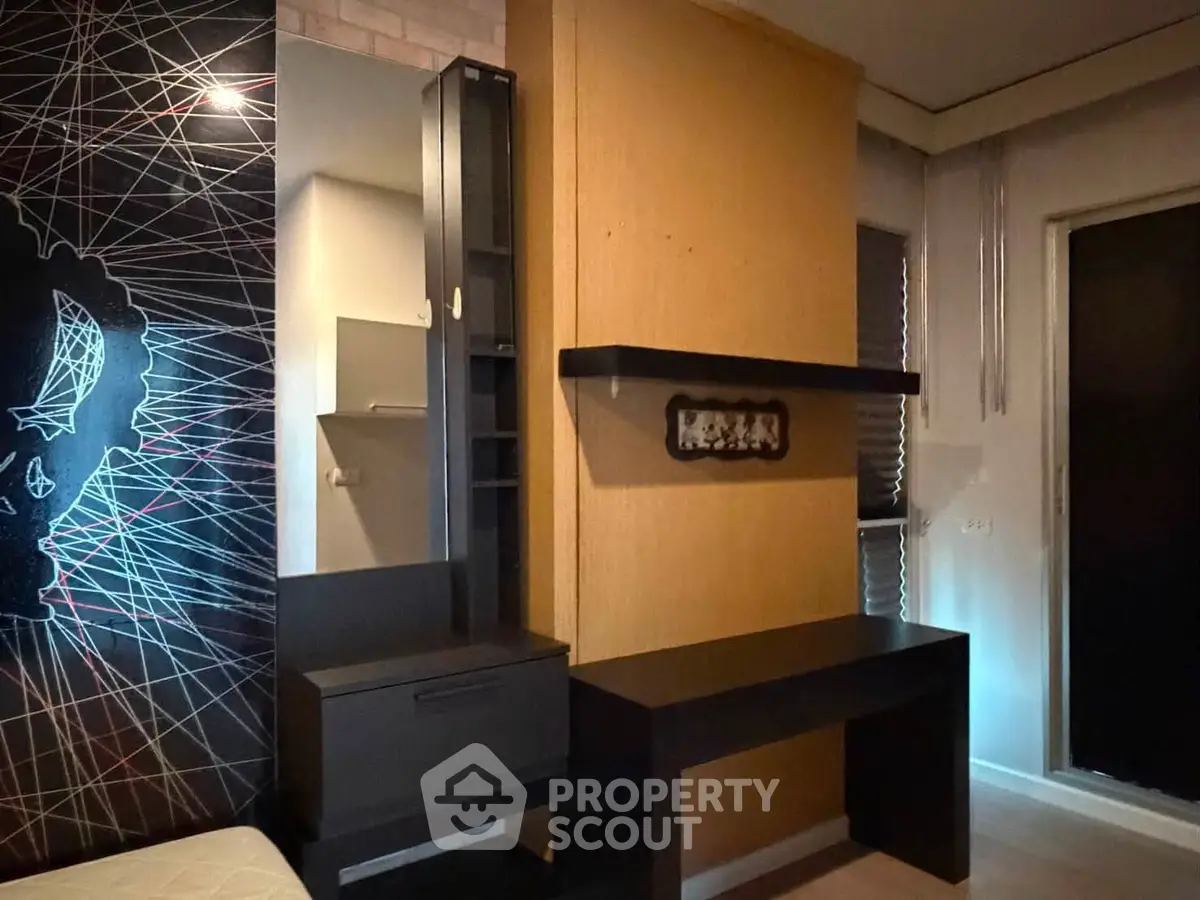 Modern interior with sleek black furniture and artistic wall design in a stylish living space.