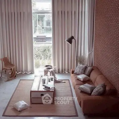 Stylish living room with tall windows, cozy sofa, and modern decor.