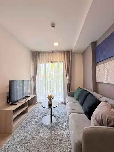 Modern living room with cozy sofa, stylish decor, and natural light from large window.