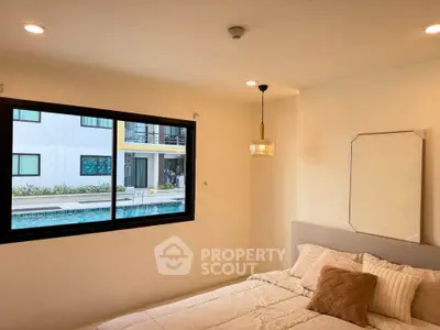 Cozy bedroom with pool view, modern lighting, and elegant decor in a stylish apartment.
