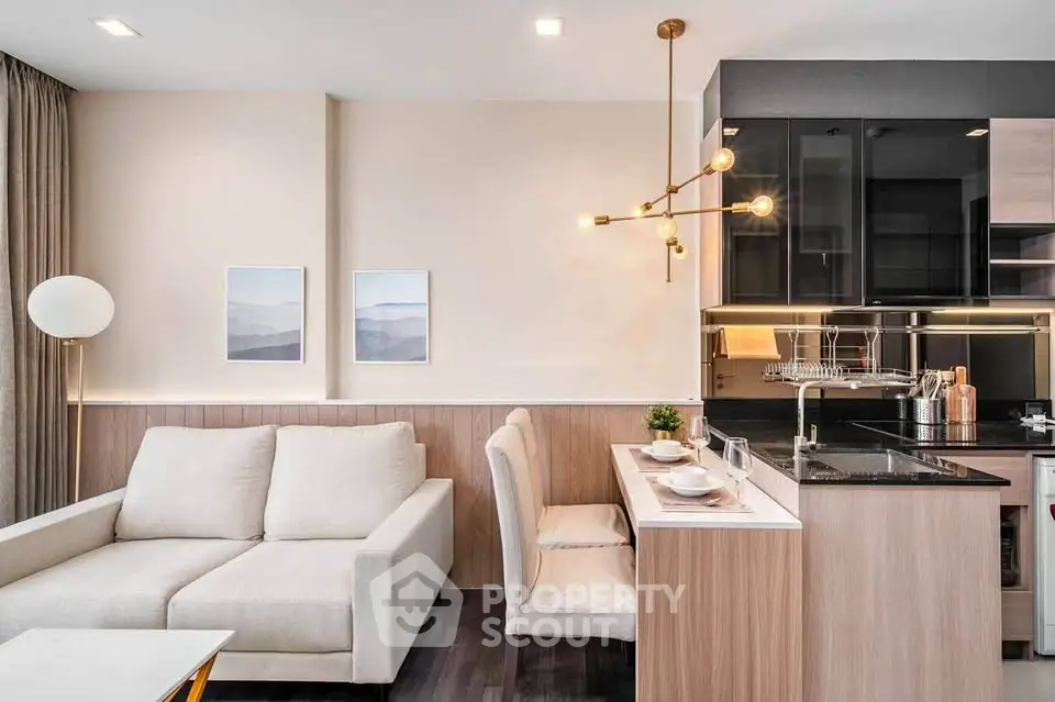 Modern open-layout living room with stylish kitchen and elegant lighting in a cozy apartment.