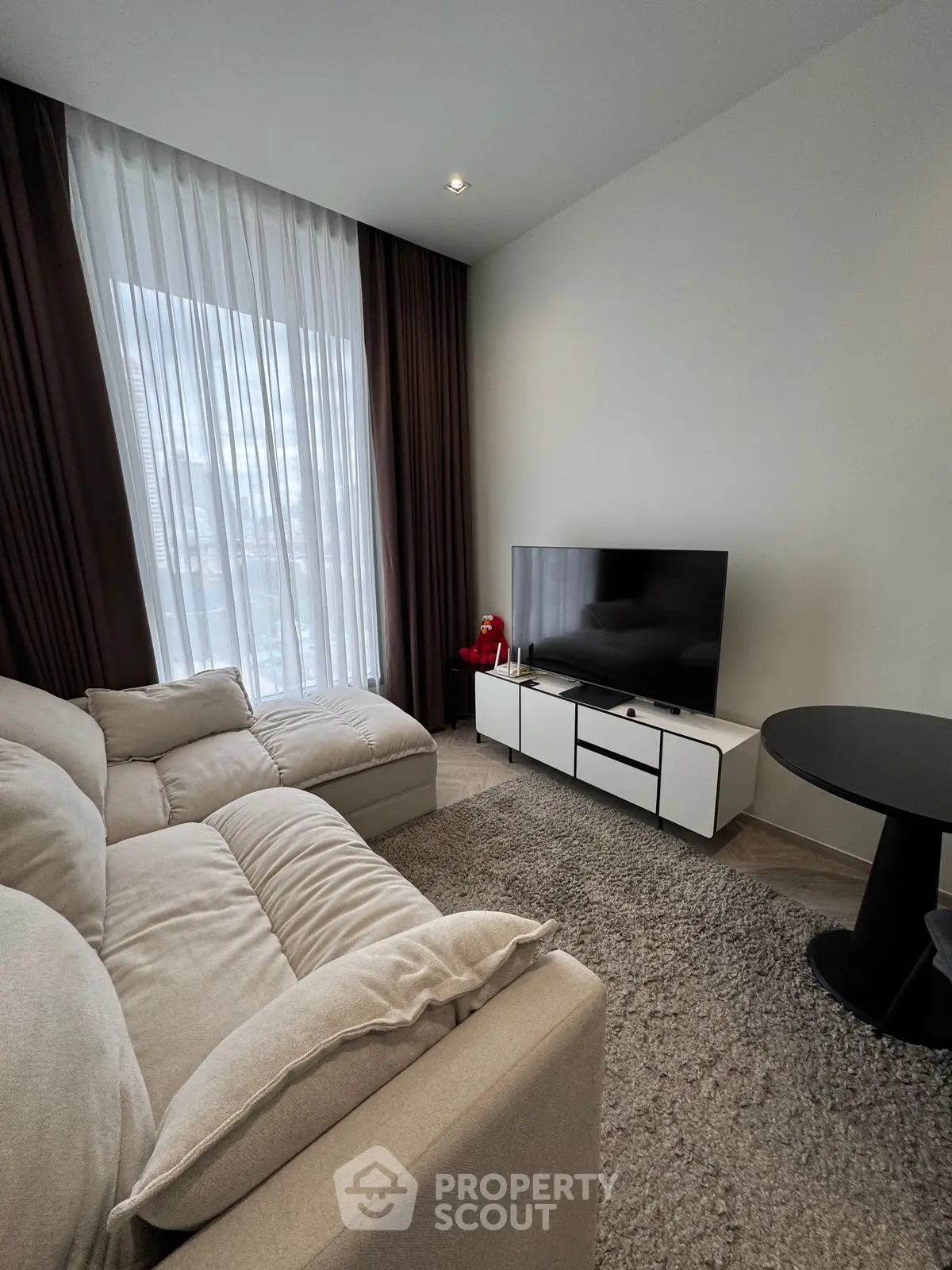 Modern living room with cozy sofa and large TV, perfect for relaxation.