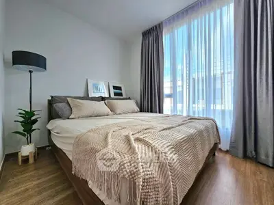Cozy bedroom with modern decor and large window for natural light