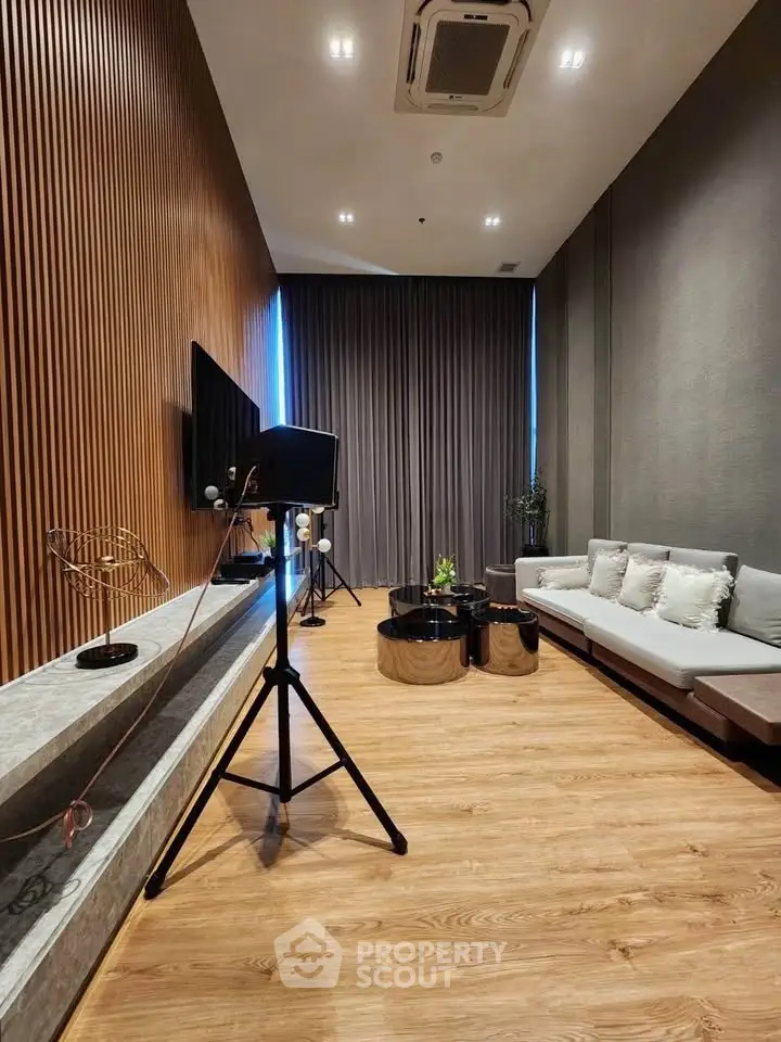 Modern living room with stylish decor and wooden flooring, featuring a cozy sofa and elegant lighting.