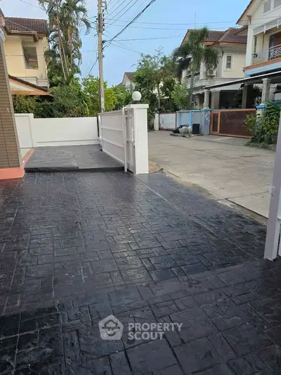 Charming residential driveway with gated entrance in a suburban neighborhood, ideal for family living.