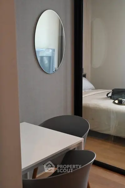 Modern bedroom with stylish mirror and cozy seating area, perfect for relaxation and comfort.