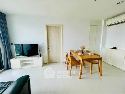 Modern living room with dining area, TV, and air conditioning in a bright apartment.