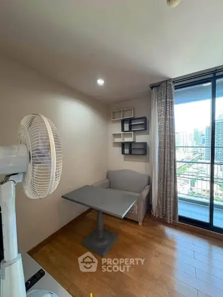 Cozy corner unit with city view and balcony access, featuring modern decor and wooden flooring.