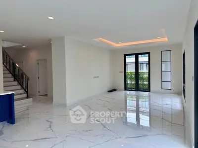 Spacious modern living room with marble flooring and elegant staircase