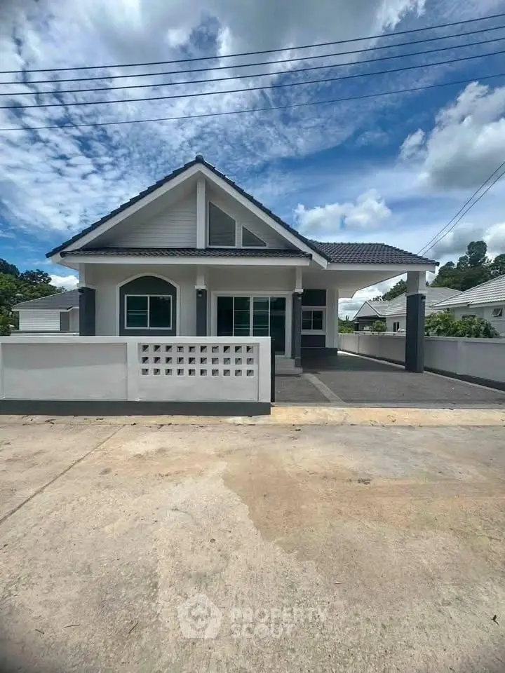 Charming single-story house with modern design and spacious driveway under a clear blue sky.