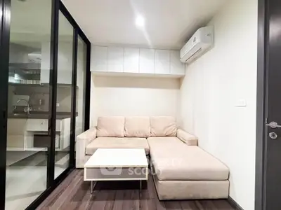 Modern living room with beige sectional sofa and glass partition, featuring sleek air conditioning unit.