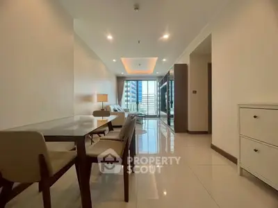 Spacious modern living room with dining area and city view, featuring sleek furniture and elegant lighting.