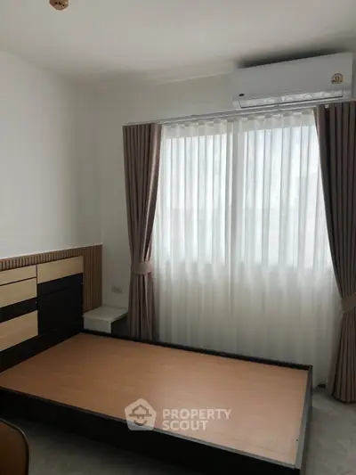 Modern bedroom with natural light and air conditioning, featuring sleek design and neutral tones.