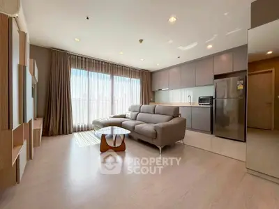 Spacious modern living room with sleek kitchen and large windows in a stylish apartment.