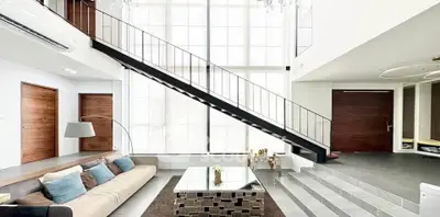 Luxurious modern living room with high ceilings and elegant staircase