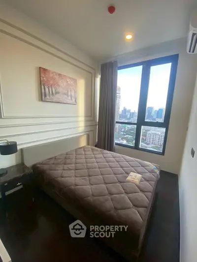 Cozy bedroom with city view, featuring a plush bed and elegant decor, perfect for urban living.