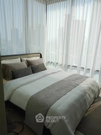 Luxurious corner bedroom with floor-to-ceiling windows and stunning city view.