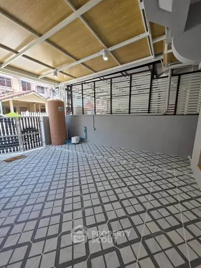 Spacious covered patio with modern tile flooring and privacy screens, perfect for outdoor relaxation.