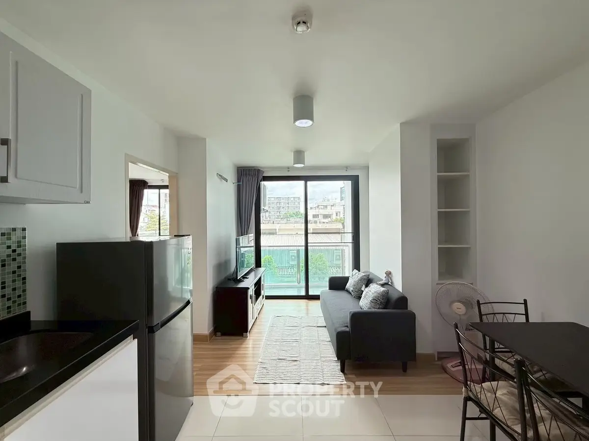 Modern living room with balcony view, featuring sleek furniture and natural light.