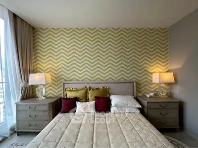 Luxurious bedroom with stylish chevron accent wall and elegant bedside lamps.