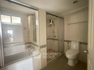 Modern bathroom with bathtub and shower in a sleek real estate property.