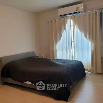 Cozy bedroom with air conditioning and natural light through curtains
