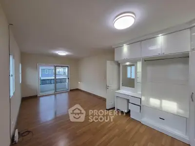 Spacious empty room with wooden flooring and built-in storage, ideal for customization.