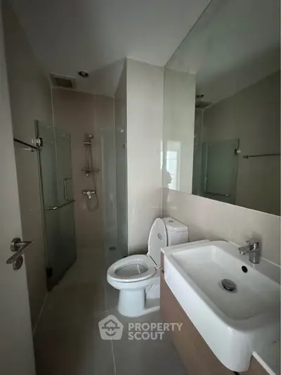 Modern bathroom with glass shower and sleek fixtures in a contemporary apartment.