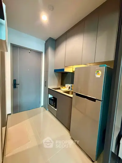 Modern kitchen with sleek cabinetry and stainless steel appliances in a compact layout.