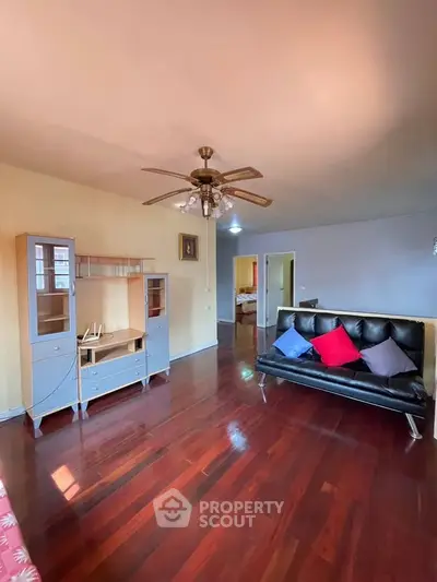 Spacious living room with wooden floors and modern furniture, perfect for relaxation and entertainment.