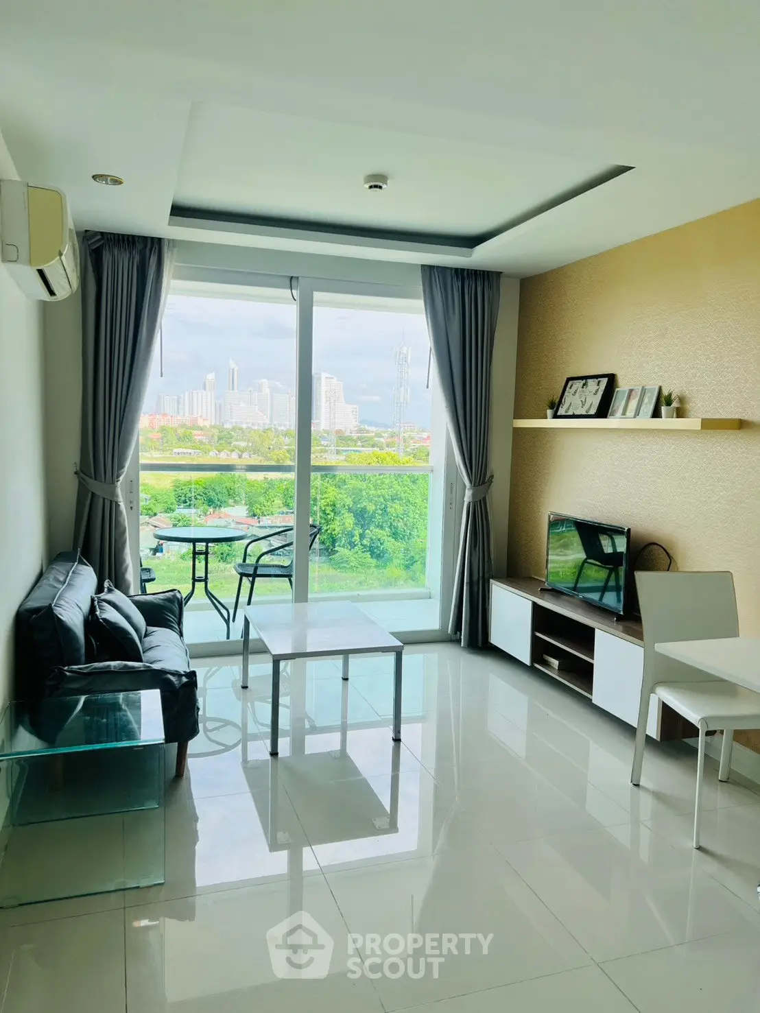 Modern living room with city view, sleek furniture, and large windows in a high-rise apartment.