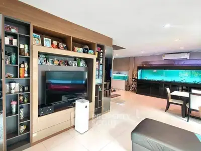 Spacious living room with built-in shelves and large aquarium, perfect for modern family living.