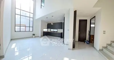 Spacious modern living room with high ceilings and open kitchen layout