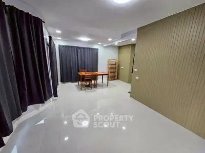 Spacious modern living room with sleek tile flooring and elegant curtains, perfect for stylish living.