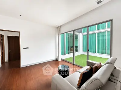 Spacious modern living room with large windows and elegant wooden flooring