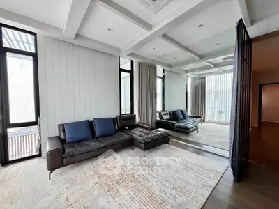 Spacious modern living room with elegant leather sofa and large windows
