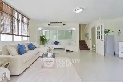 Spacious and bright living room with modern decor and large windows in a stylish home.