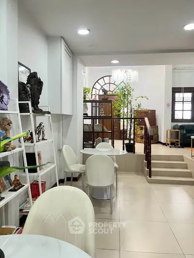 Elegant interior with modern furniture and stylish decor, featuring a cozy seating area and decorative shelving.