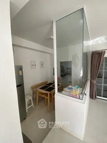 Modern kitchen with dining area and glass partition in a bright apartment.