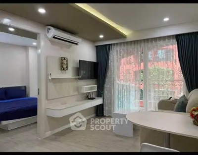 Modern living room with open layout, featuring a cozy bedroom view and stylish furnishings.