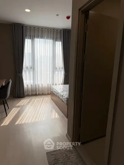 Cozy bedroom with natural light and modern decor in a stylish apartment.