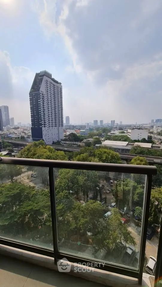 Stunning cityscape view from a high-rise balcony with lush greenery and modern architecture.