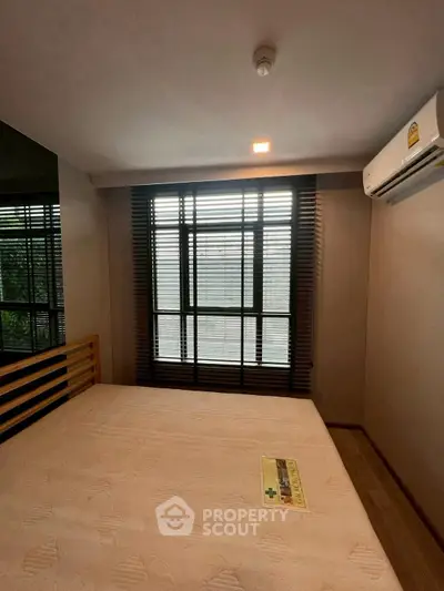 Cozy bedroom with large window and air conditioning, perfect for relaxation.