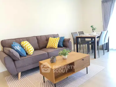 Modern living room with stylish sofa, vibrant cushions, and elegant dining area, perfect for cozy gatherings.
