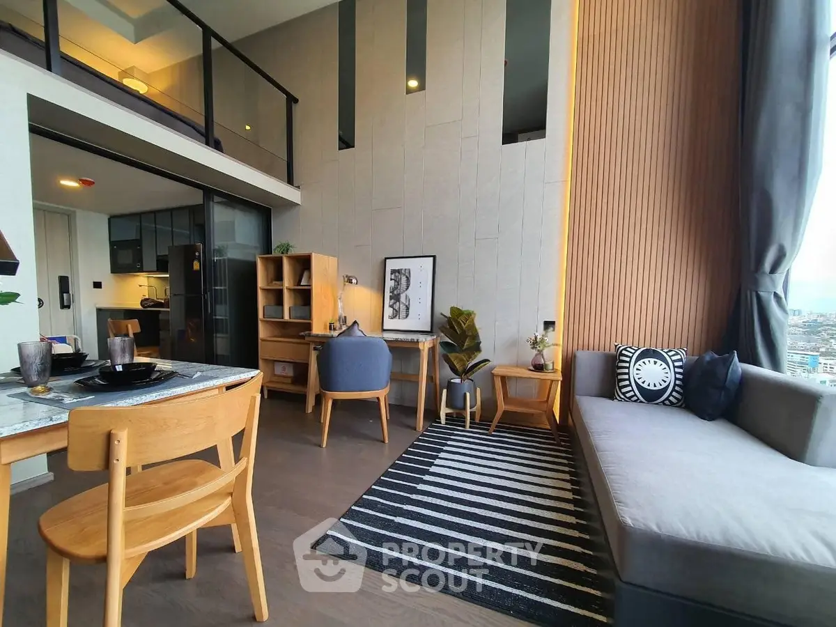 Modern living room with stylish decor and open kitchen layout in high-rise apartment