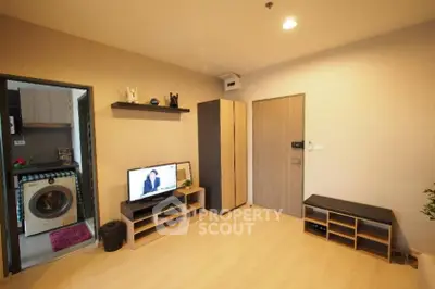 Modern living room with TV and washing machine in open layout apartment