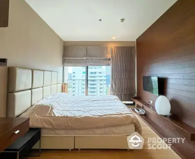 Luxurious modern bedroom with large window and stylish decor in urban apartment.