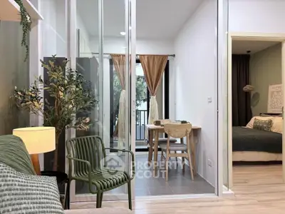 Modern apartment interior with open living and dining area, featuring stylish decor and a glimpse of the bedroom.